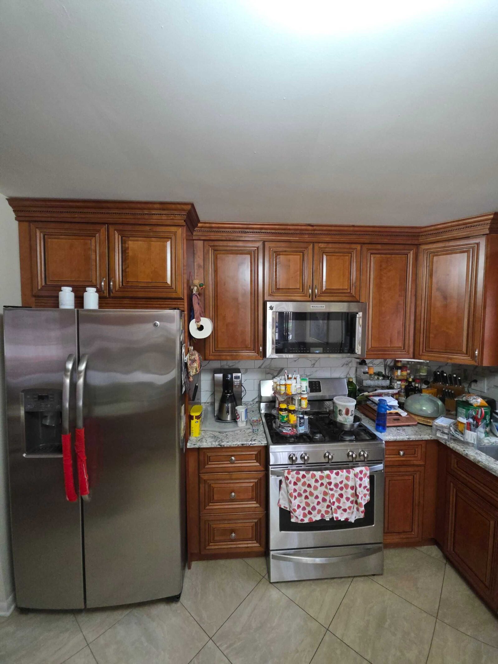 Before: the range and refrigerator wall in granite, cherry cabinets above