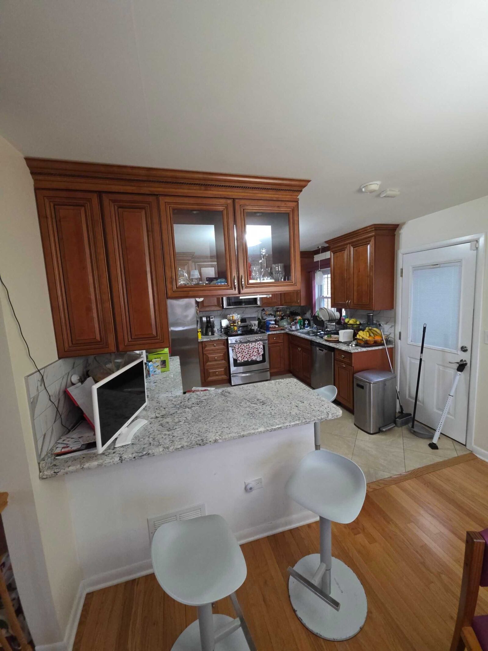 The same peninsula before, in speckled granite with a microwave sitting on the counter
