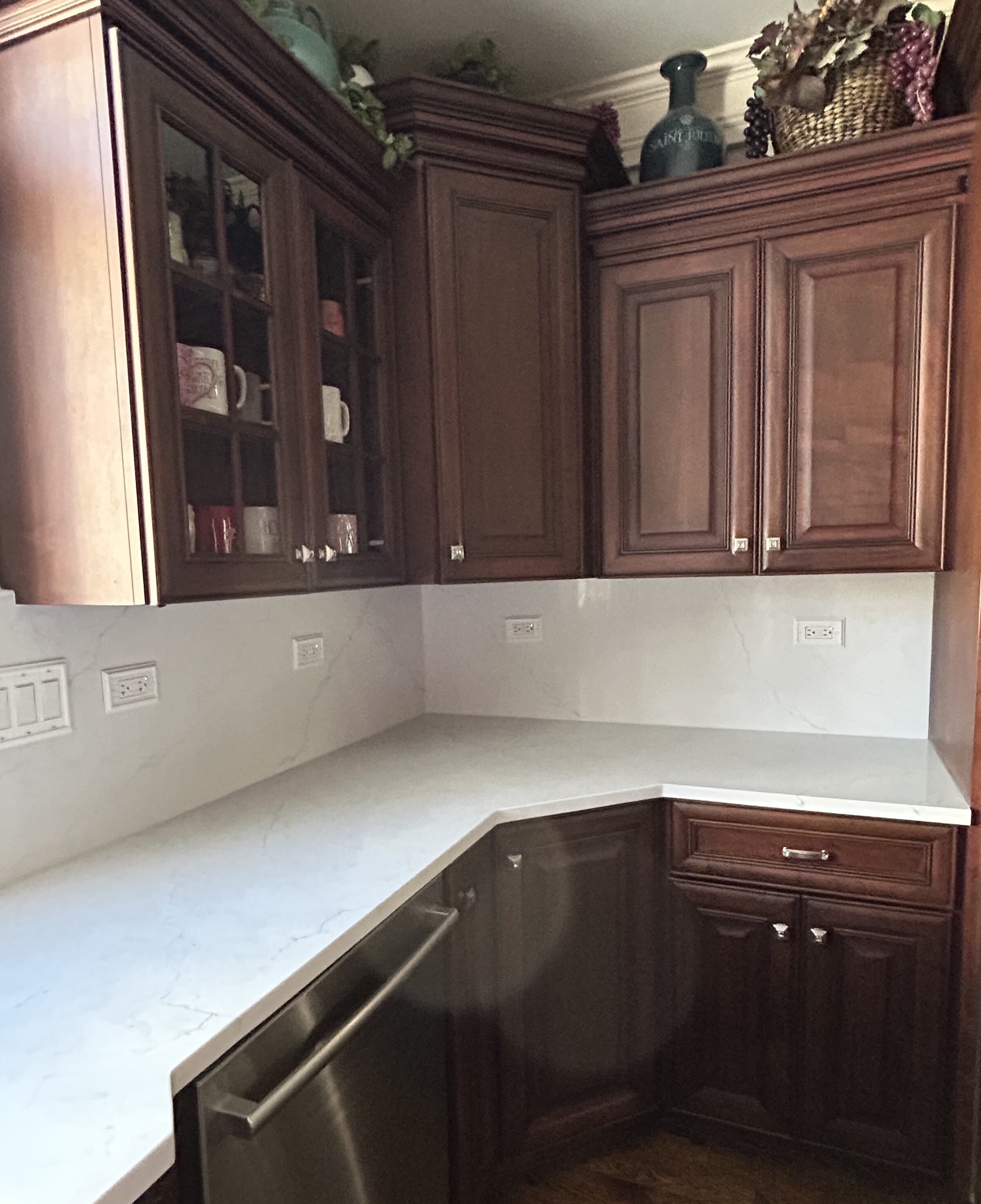 New white quartz counter running under the window to an undermount sink and gooseneck faucet