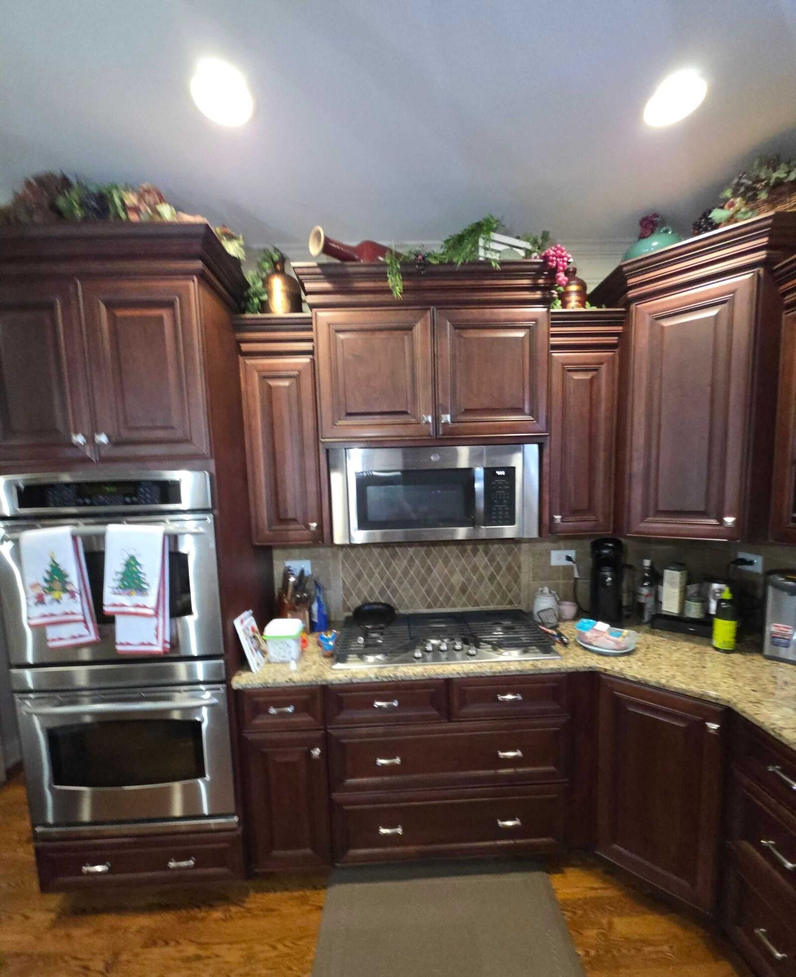 Before: double wall ovens set into cherry cabinetry with the original granite alongside