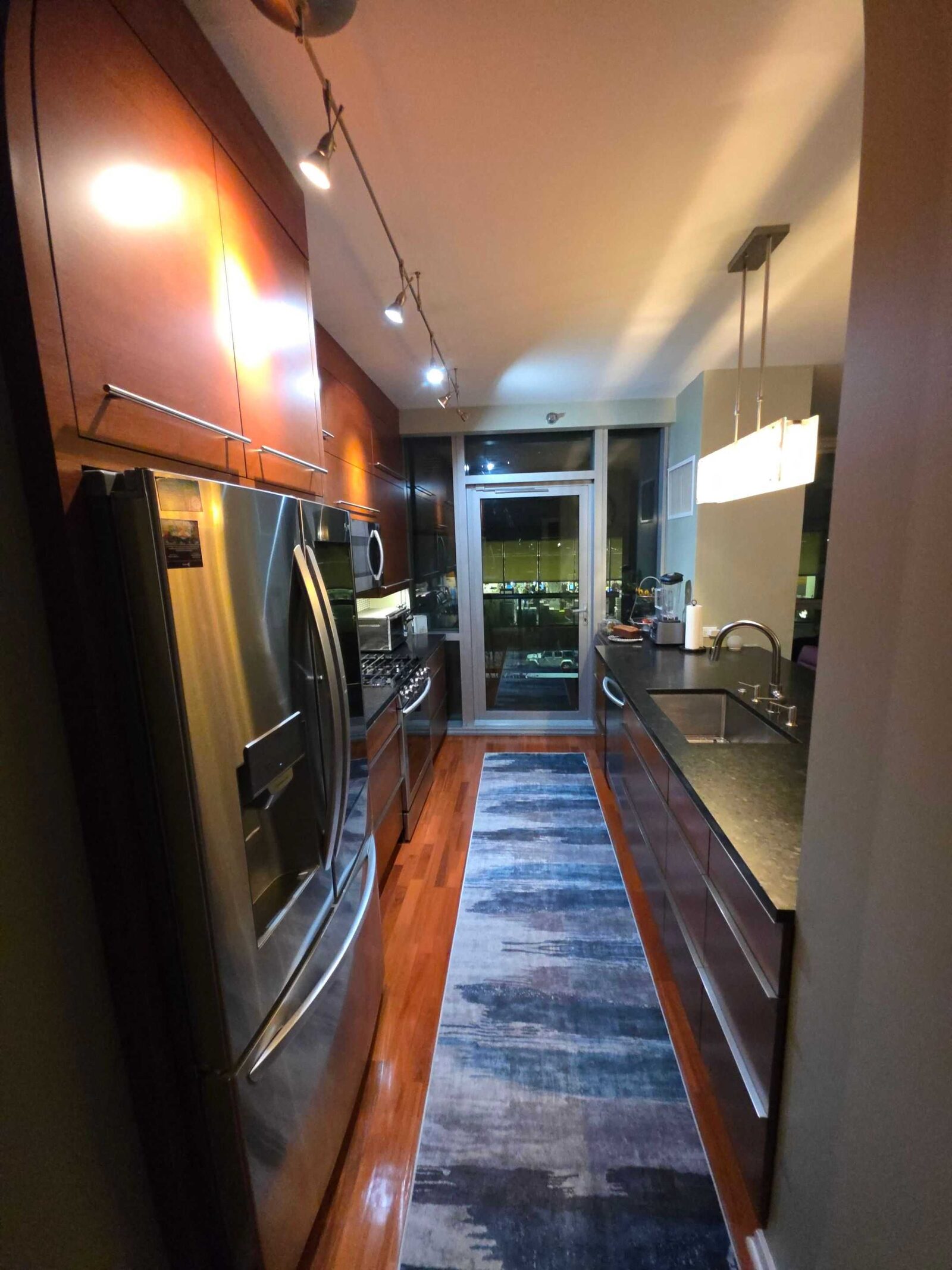 Before: the galley at night, dark counters running past the refrigerator to the balcony door