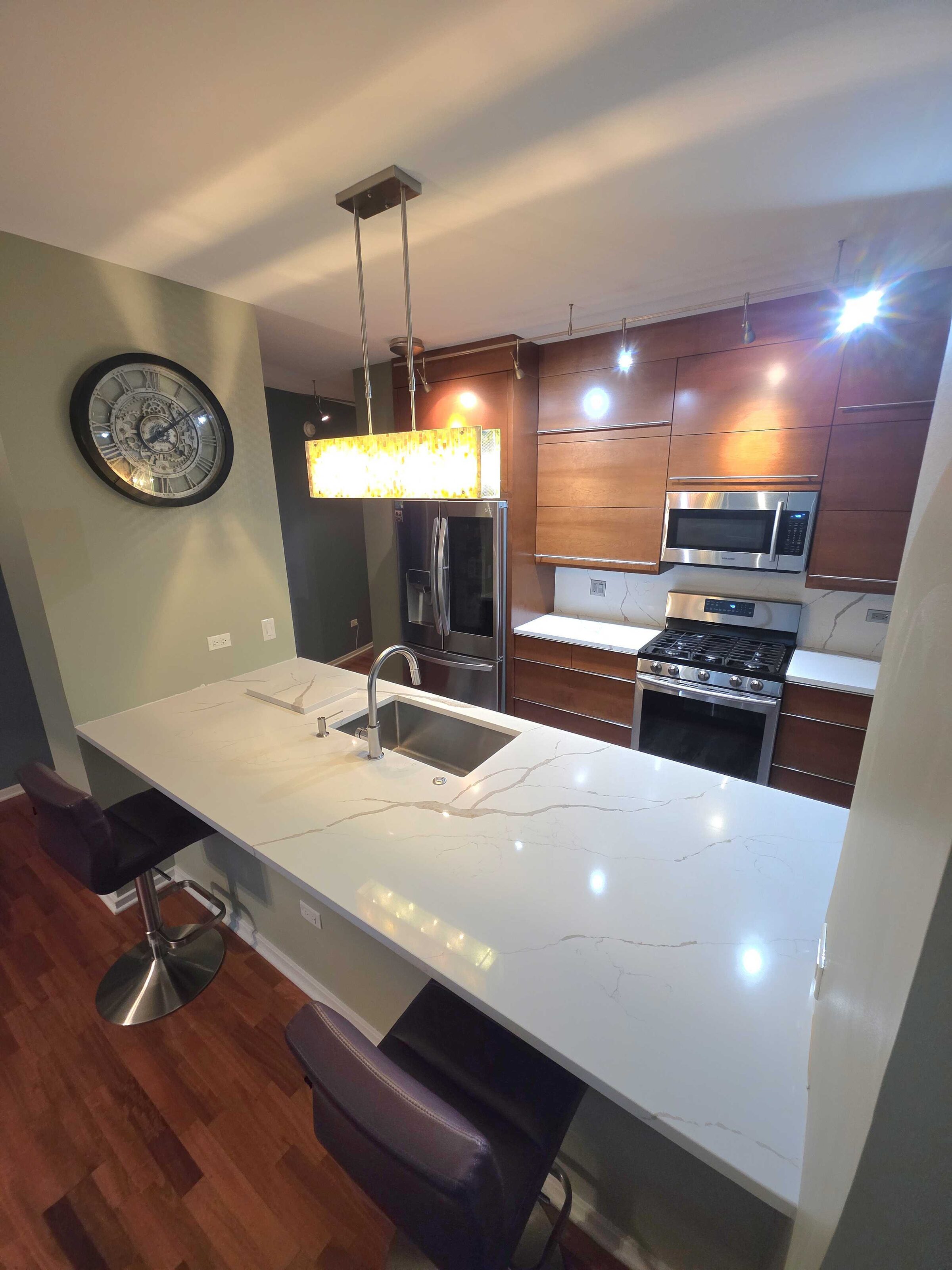 Quartz bar and sink run seen down the length of the galley toward the window wall