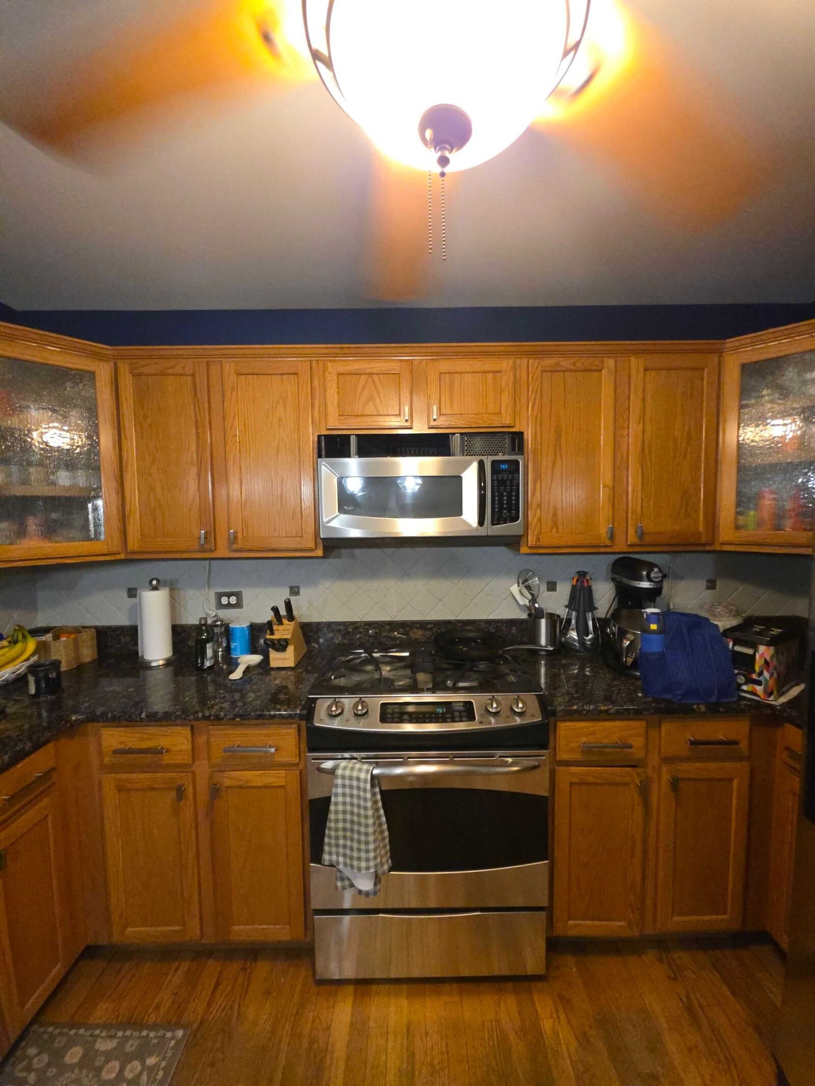 Before: the range wall in dark granite, with the old counter running to the corner